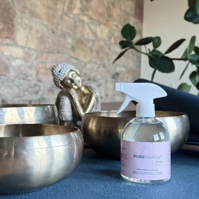 Desinfizierender Yogamatten Reiniger Puremanent Yoga in einem Yogastudio vor Klangschalen
